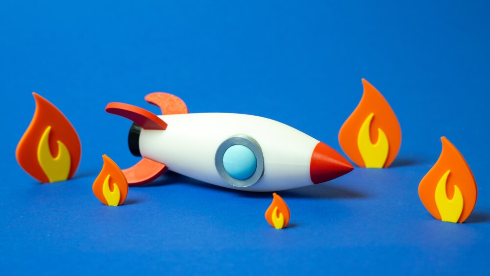 Space rocket crashed and on fire. Business failure, failed startup. Downfall of ambitious plans, flawed execution, or crisis outcomes. Volatility of startups, financial risks, or unexpected setbacks.