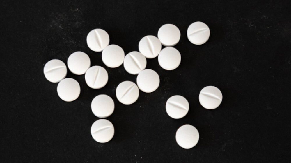 Pictured: White pills on a black background/iStock