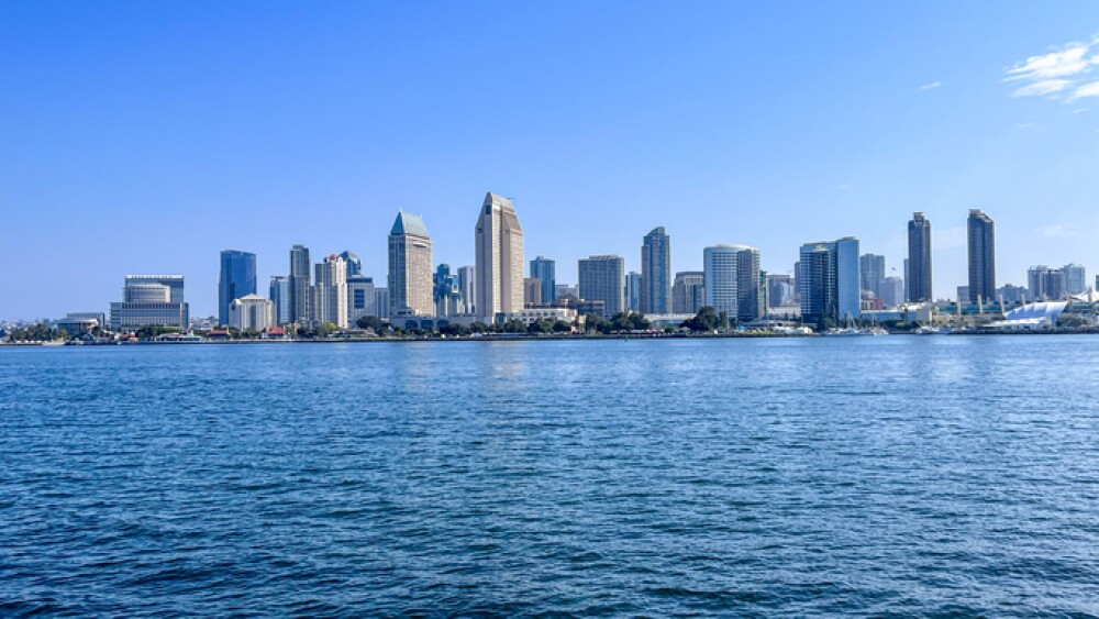 Panoramic view of San Diego skyline with clear blue sky and calm ocean waters.