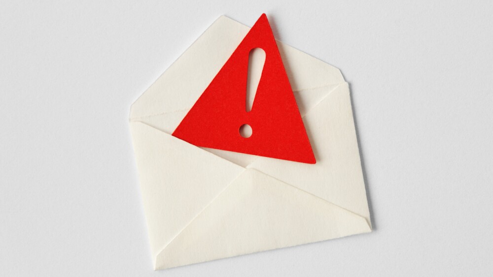Email envelope with warning sign on white background