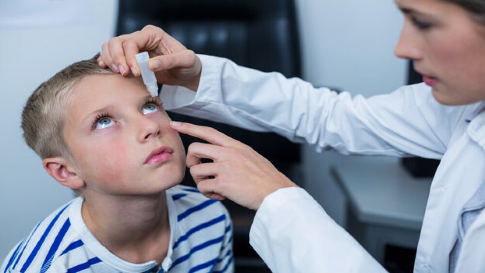 Pictured: Doctor administers eye drops to a boy/iS