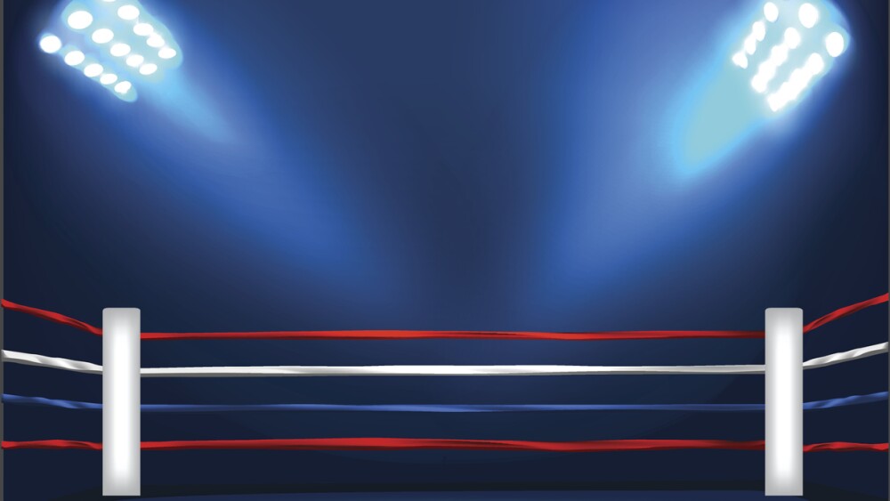 Indoor boxing ring corner with flooding spotlight .