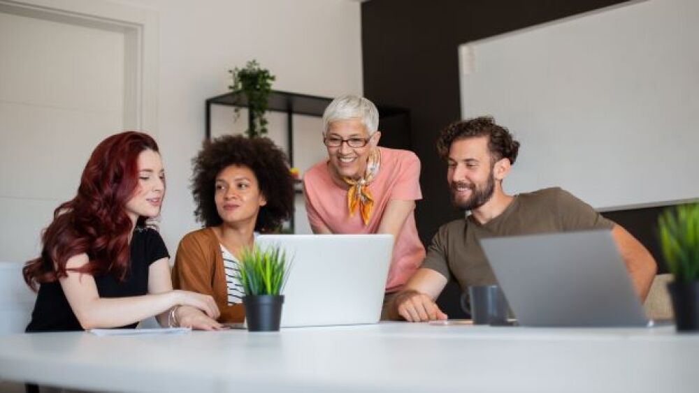 Photo shows employees looking at a computer/Getty