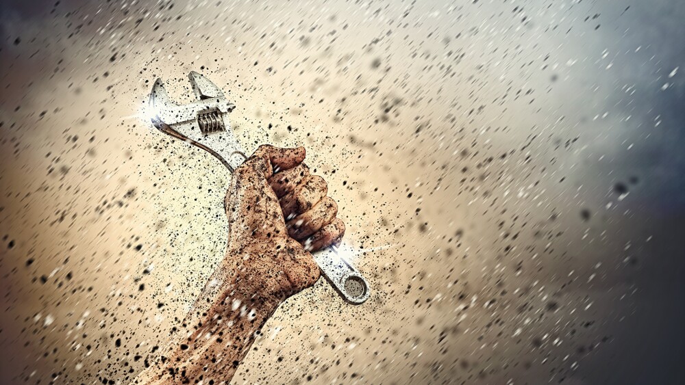 Close-up image of human hand holding wrench. Construction