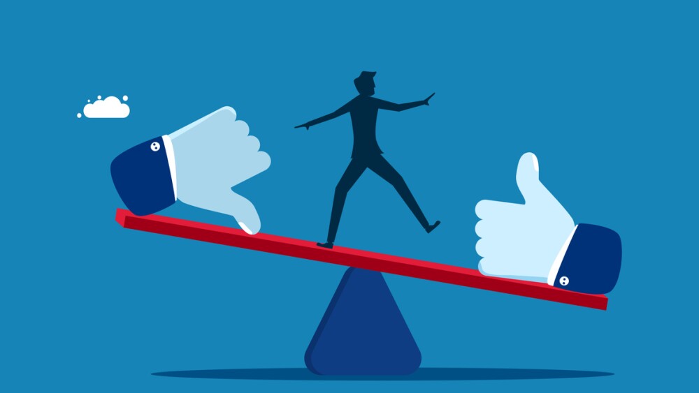 Businessman balancing on seesaw with thumb up and thumb down