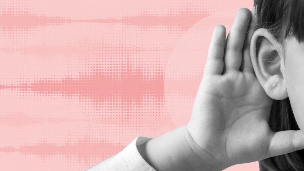 A child cups their ear with hand