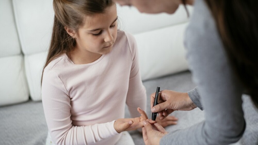 Measuring Blood Sugar Level Of Girl With Glucometer stock photo. Shadow DOF. Developed from RAW; retouched with special care and attention; Small amount of grain added for best final impression. 16 bit Adobe RGB color profile.