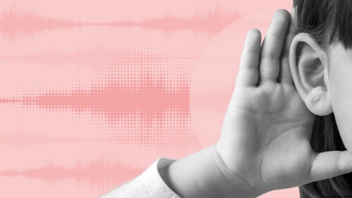 A child cups their ear with hand