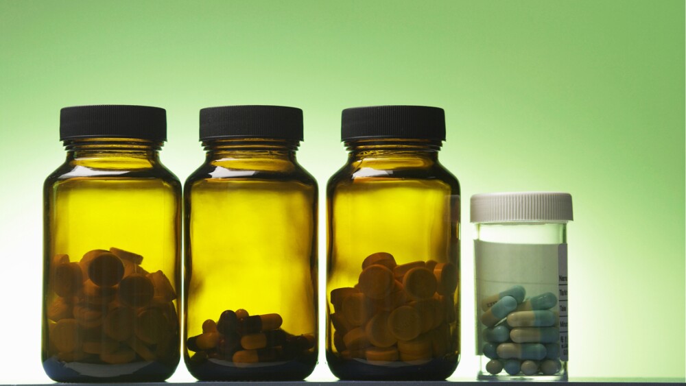 Close-Up Of Medicine Bottles Against Green Background