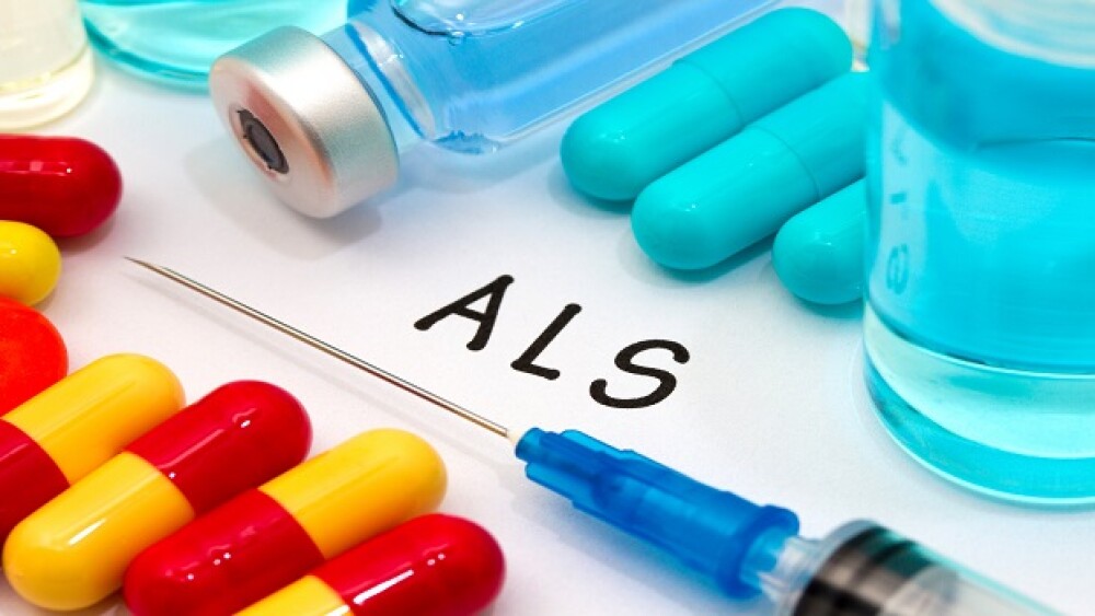 ALS - diagnosis written on a white piece of paper. Syringe and vaccine with drugs.