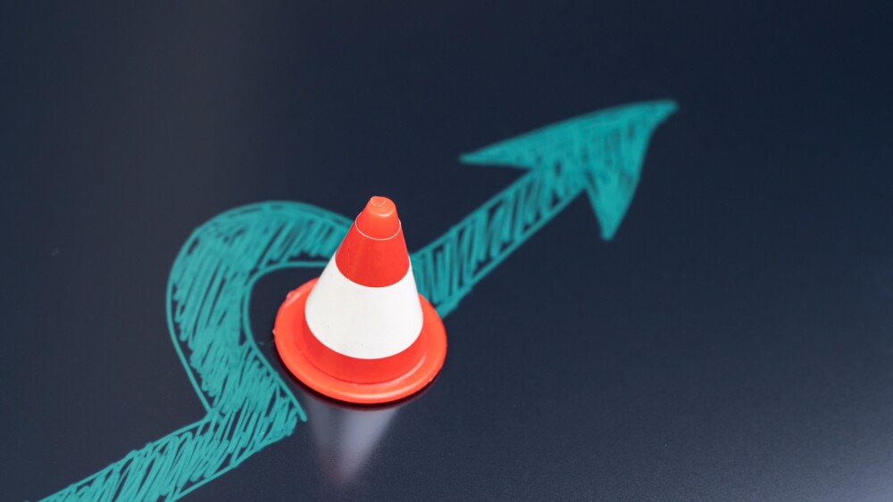 Chalk drawing arrow turn or break through road block traffic pylon on dark blackboard using as obstacle, solution for business problem or break through to success concept.