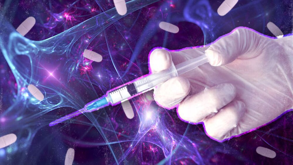 Pictured: A hand holding syringe and pills over an