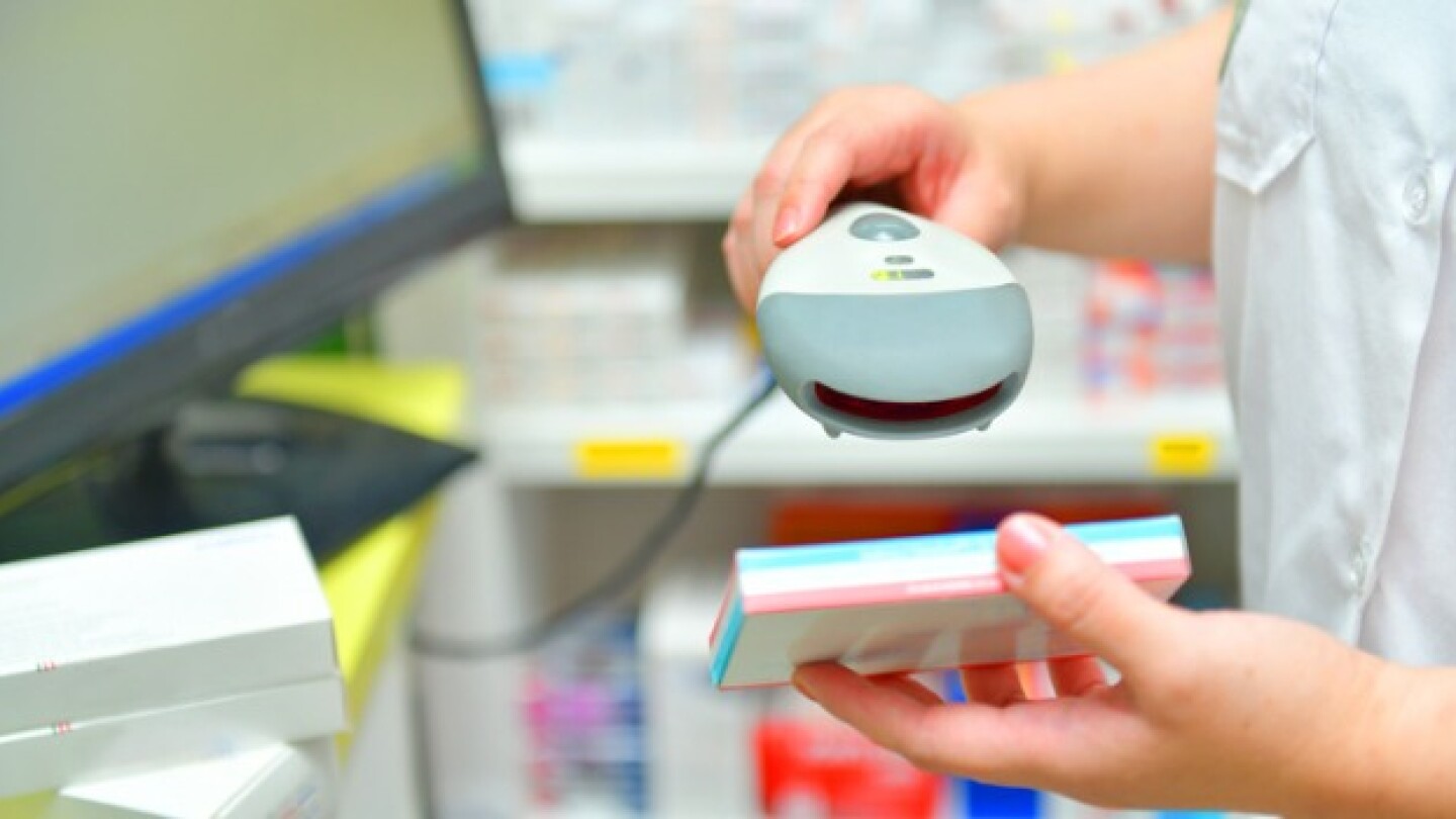 Pictured: A pharmacist ringing up a prescription m