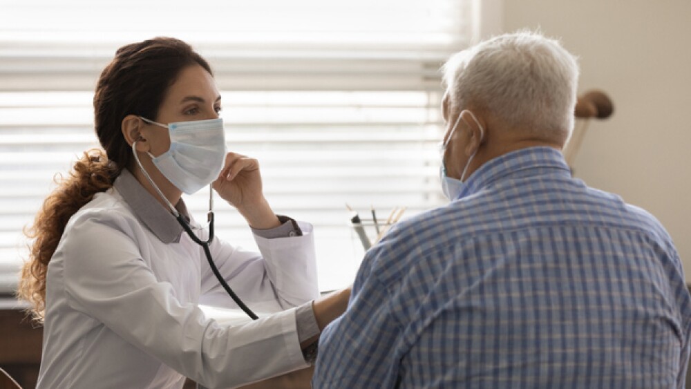 Pictured: A doctor checks an older patient’s lungs