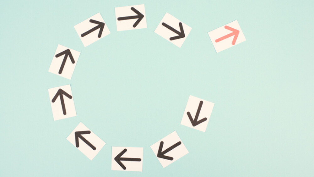 Many black arrows, one red is standing out, do different, be a winner, individuality, making your own decision, leadership