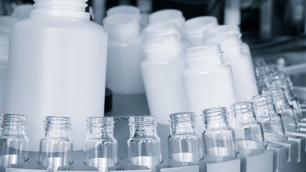 pharmaceutical industry, medicine pills are filling in the bottle on production line machine conveyor at the medical factory. selective focus.