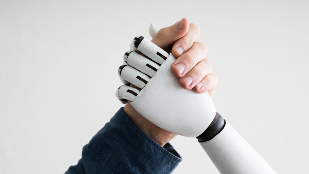 Close-up Of Businessperson Shaking Hands With Robot