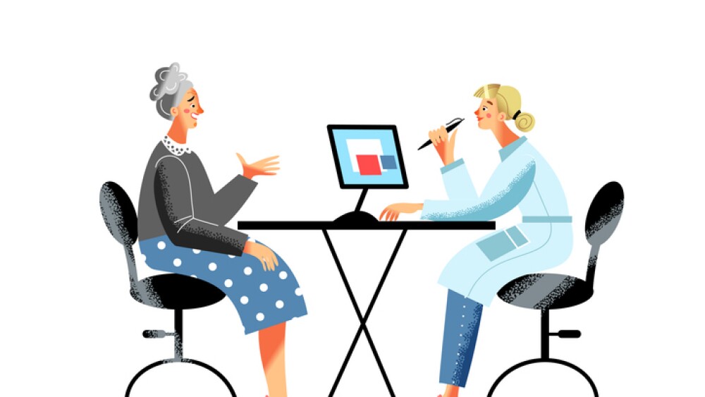 Elderly woman consulting female doctor at desk with computer