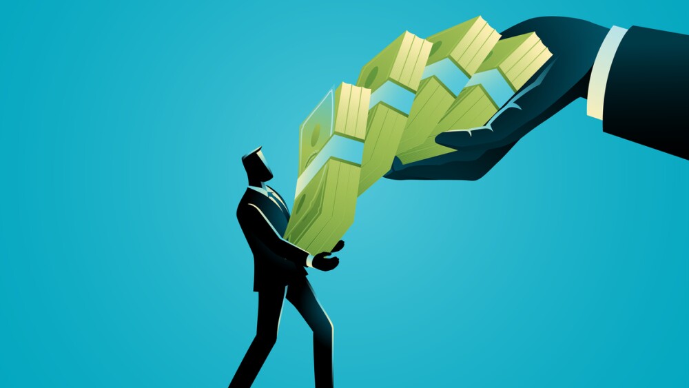 Businessman receiving large stacks of money from a giant hand. Concept of funding, venture capital, financial support, dividend, and profitable business.