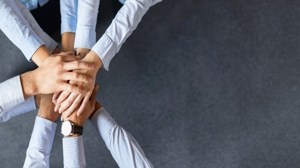 Close up top view of young business people putting their hands together. Stack of hands. Unity and teamwork concept.