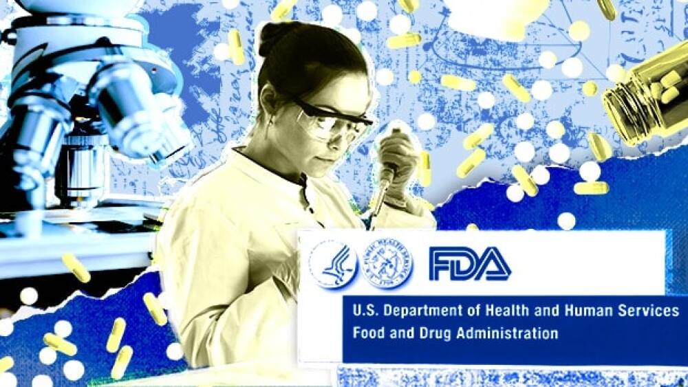 Pictured: A scientist works behind an FDA sign/Tay