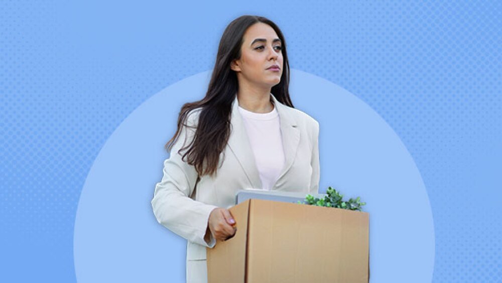 Pictured: Woman carrying box of office things