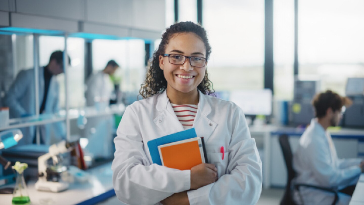 Pictured: A young woman wearing a lab coat and ho