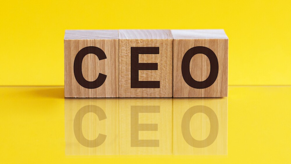 CEO word made of wooden cubes on a yellow background with copy space, business concept