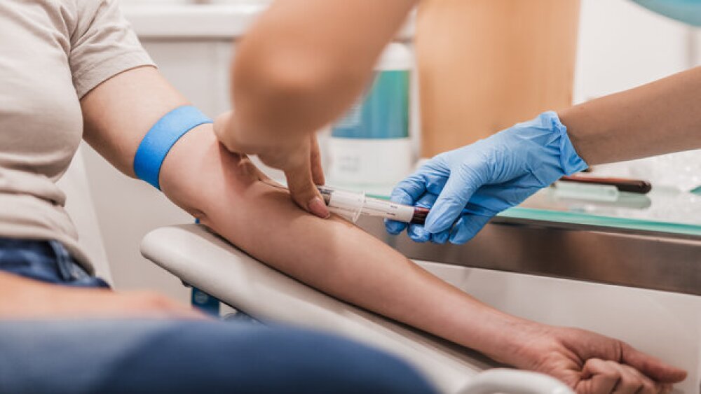 Pictured: Healthcare worker draws blood from a pat