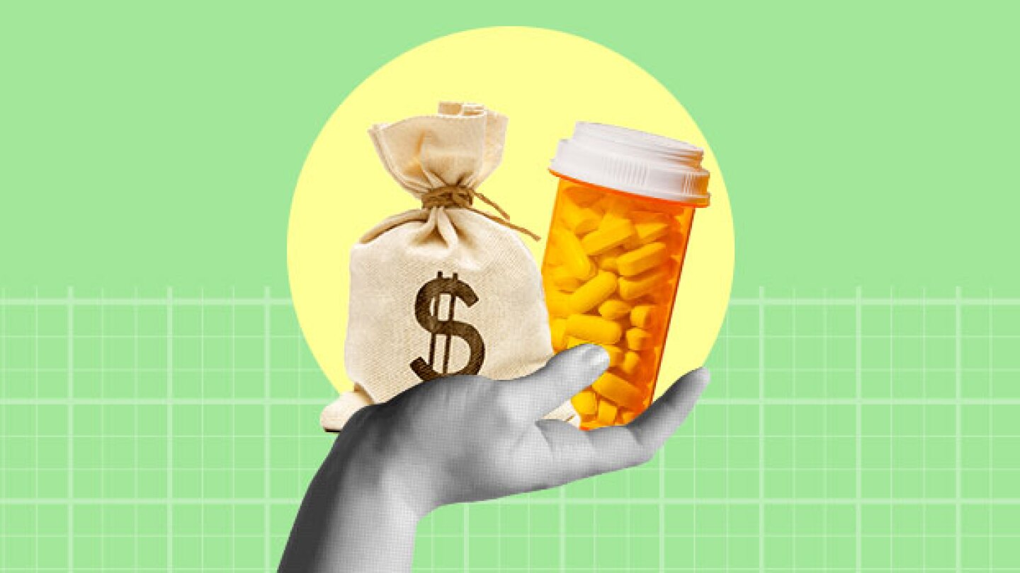 Pictured: A hand holding a bag of money and a pill