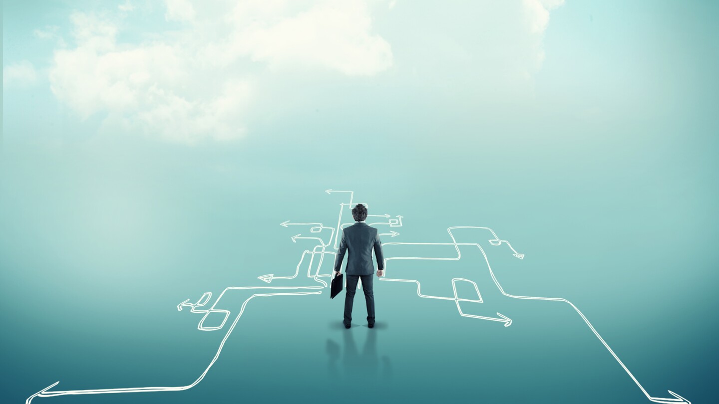 Confused businessman stands in front of different arrows . The concept of hard choices.