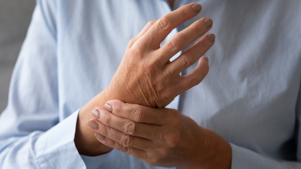 Senior lady massaging hand suffering from rheumatoid arthritis concept, old adult female patient touching wrist feeling hurt joint pain having osteoarthritis disease health problem, close up view