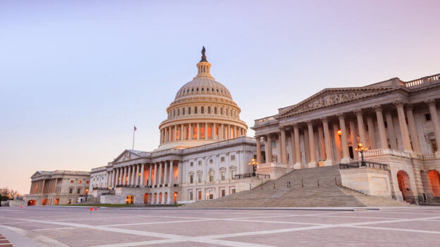 The United States Capitol building with the dome lit up at night.
