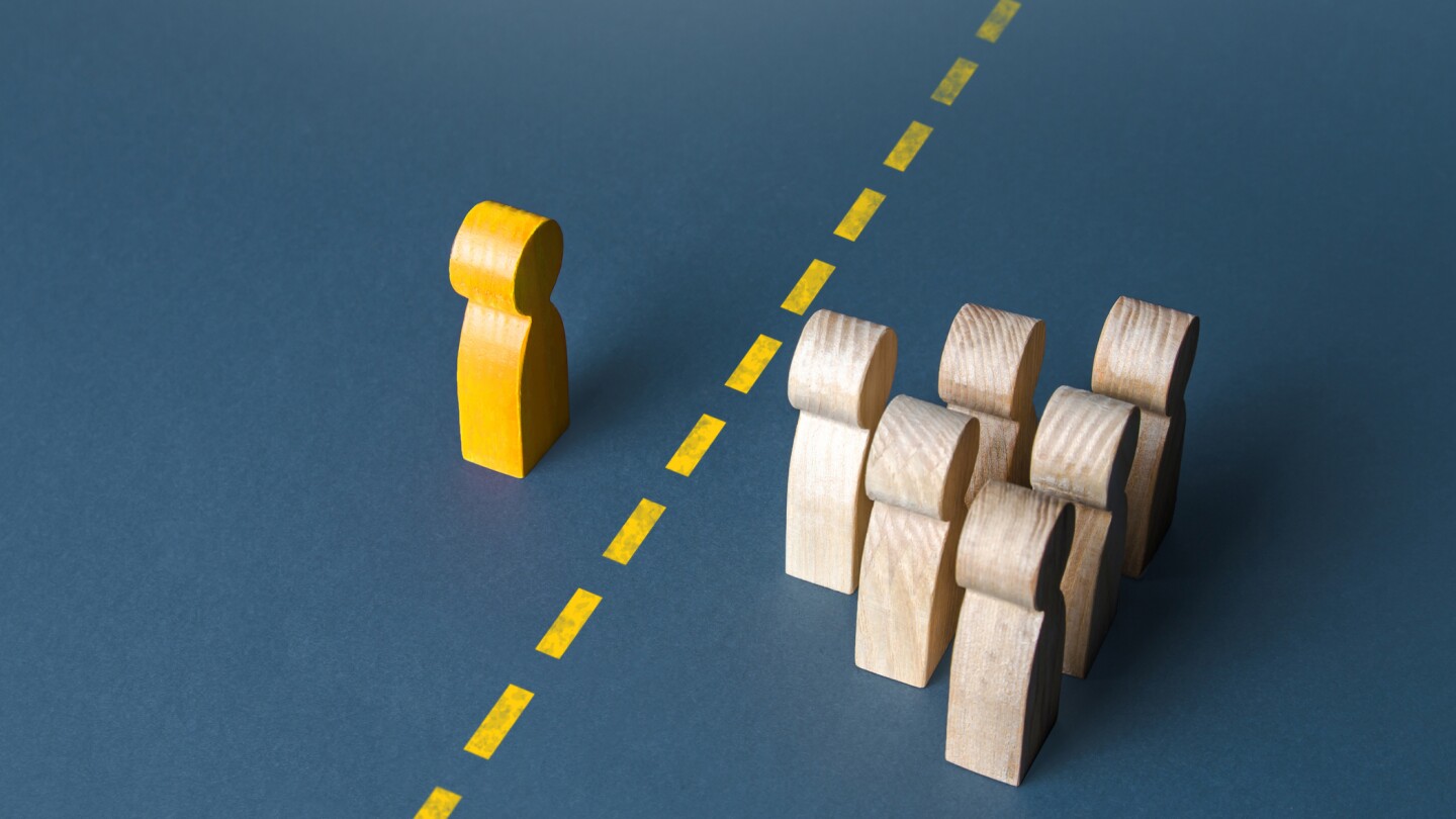 A person and a group of people are separated by a yellow line. Establishing contact. Distrust. Quarantine. Distance with strangers. Barrier to understanding, difficult integration. Rejection, refusal.