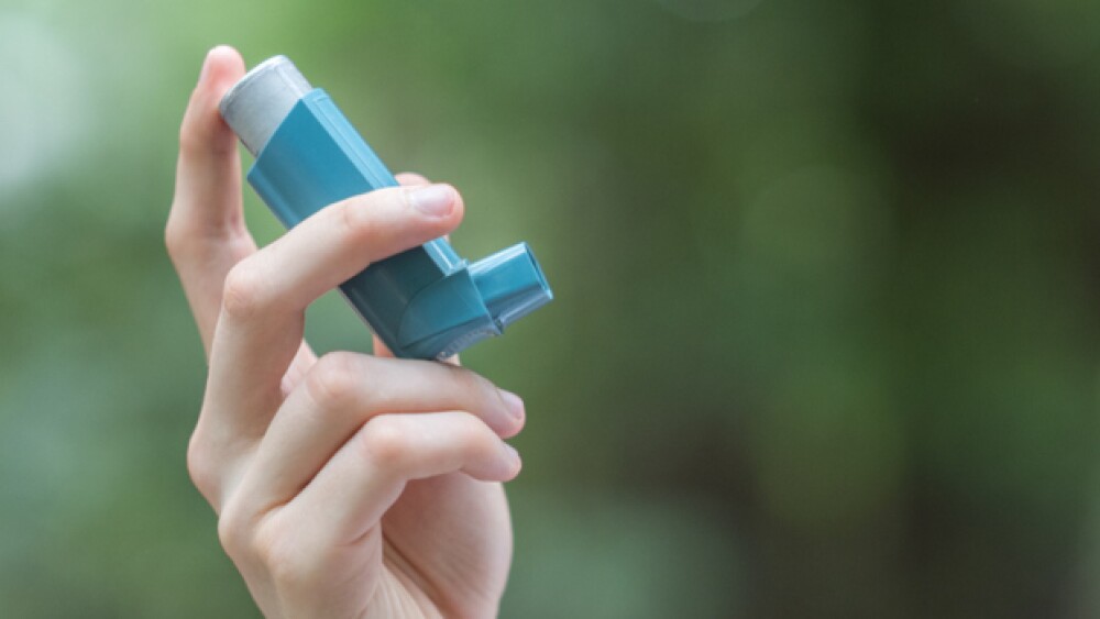 Pictured: Hand holding an inhaler