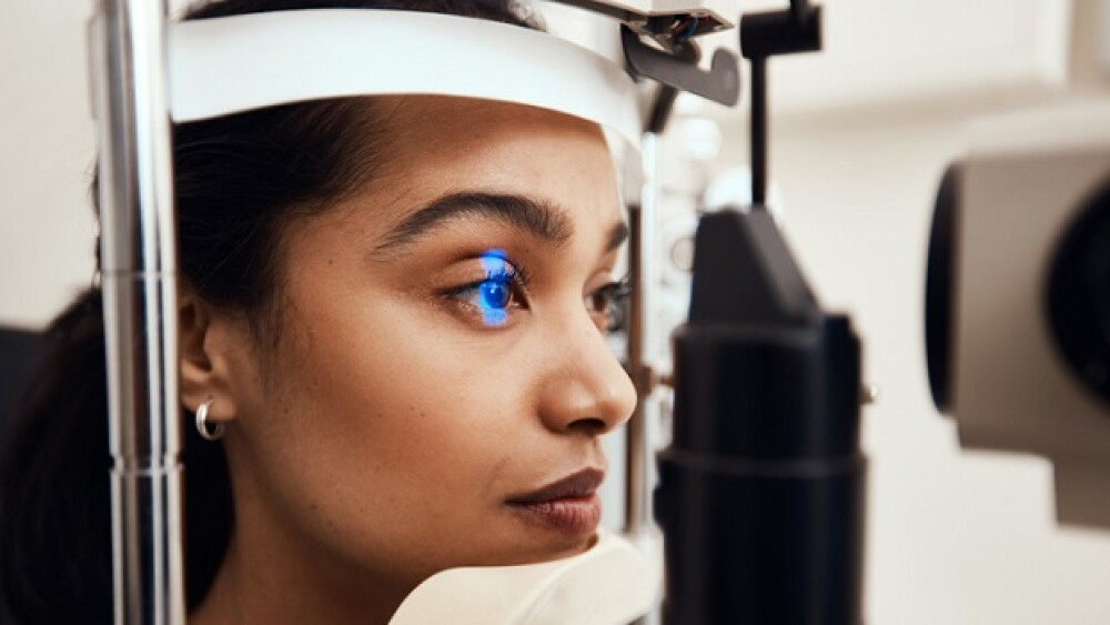 Shot of a young woman getting her eye’s examined with a slit lamp