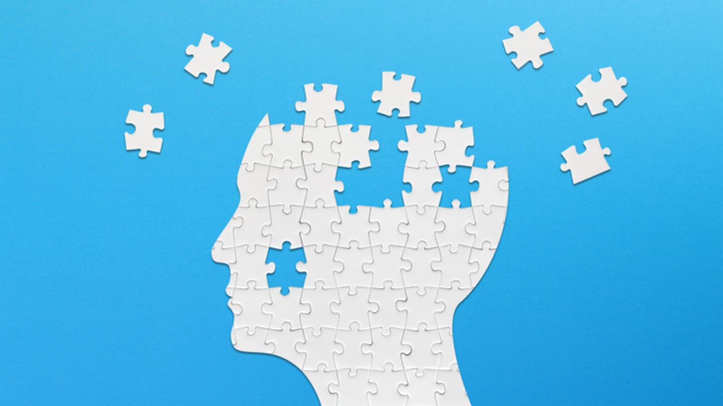 Brain shaped white jigsaw puzzle on blue background. Mental health and problems with memory.
