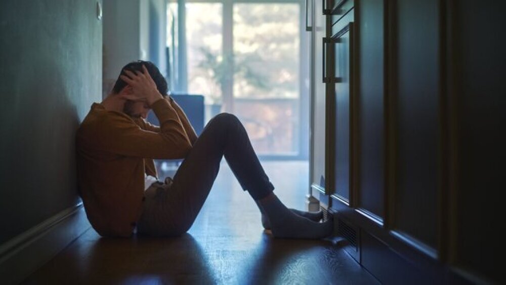 Pictured: Anxious man with his head in his hands/i