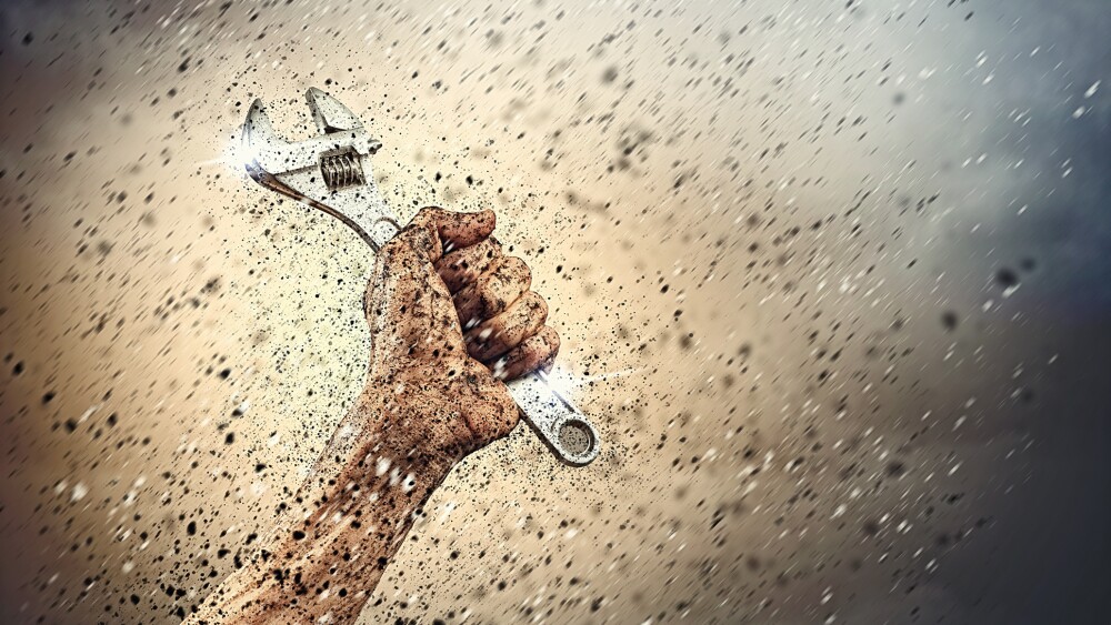 Close-up image of human hand holding wrench. Construction