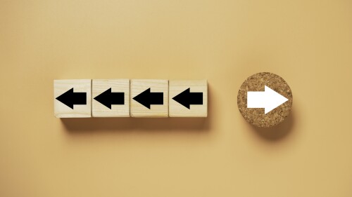 White arrow on circle wooden move on different direction with black arrow on cube for business and technology disruption concept.