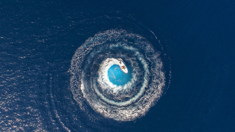 A boat is driving in a circle and produces a big whirlpool
