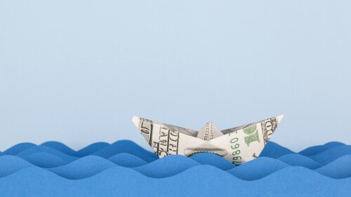 Dollar boat swimming on paper waves