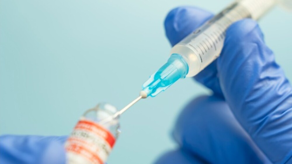 Pictured: Syringe drawing up vaccine/iStock, Diy13