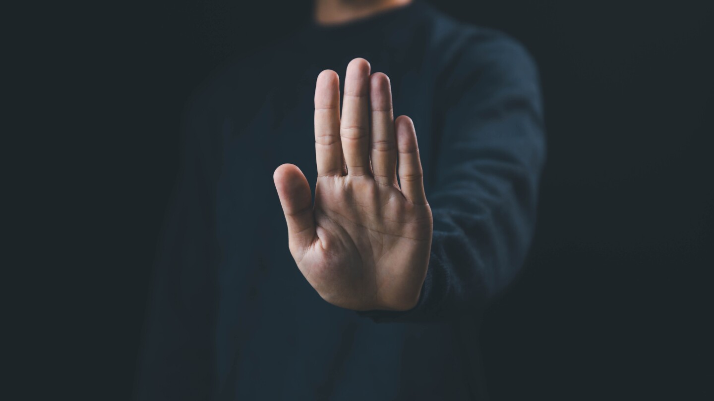 Man holds up his hand to signify a pause or stop