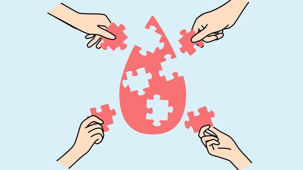 Drop of blood from puzzles in hands, as metaphor for donation and fight against cancer caused by leukocyte disease. People donate blood to help sick patients in need of plasma transfusions