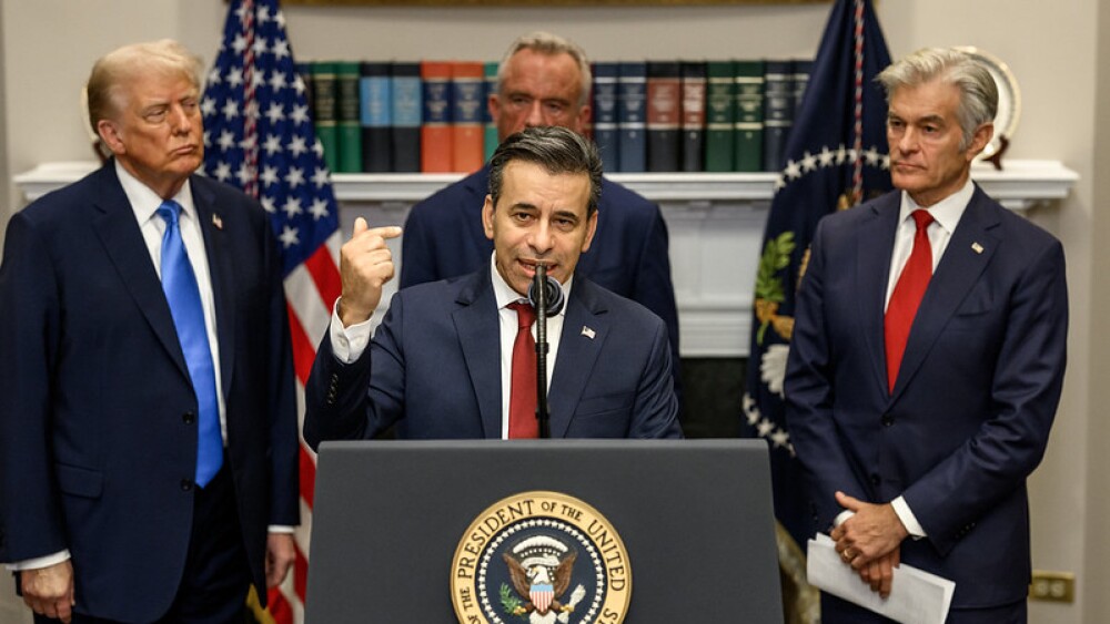 Marty Makary speaks at a podium, with President Trump, RFK Jr., and Mehmet Oz in the background.