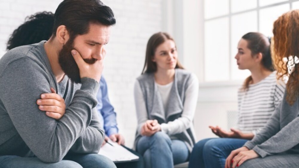 Pictured: Man feeling anxious while in a group/iSt