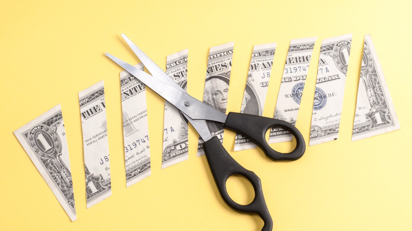 Dollar banknote cut into pieces on a yellow background
