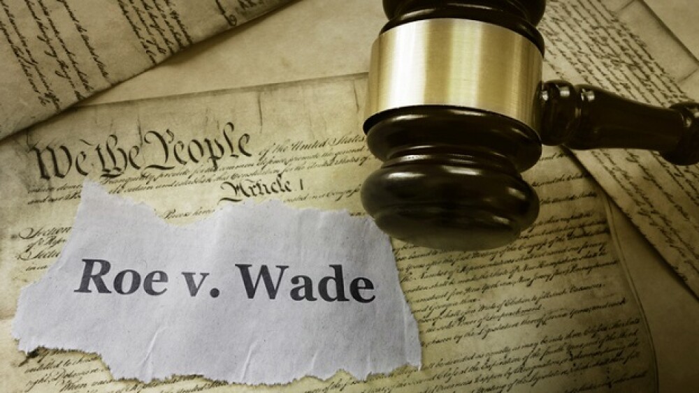 Roe v Wade news headline with gavel on a copy of the United States Constitution