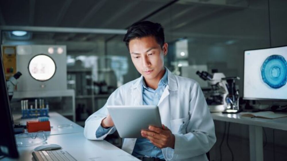 Pictured: Research associate reviews data in lab